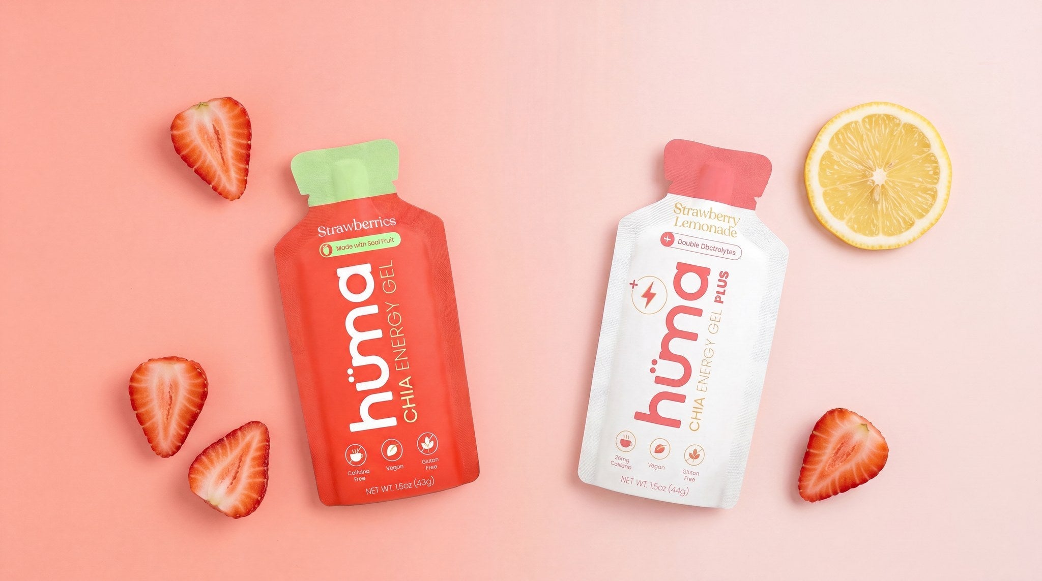 Hüma Original Strawberries gel and PLUS Strawberry Lemonade gel side by side with fresh strawberries and a lemon half.