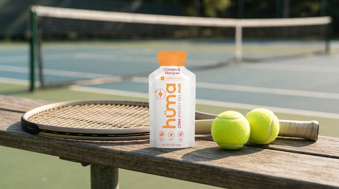 Huma PLUS Oranges and Mangoes gel on a tennis court bench with racquet and balls
