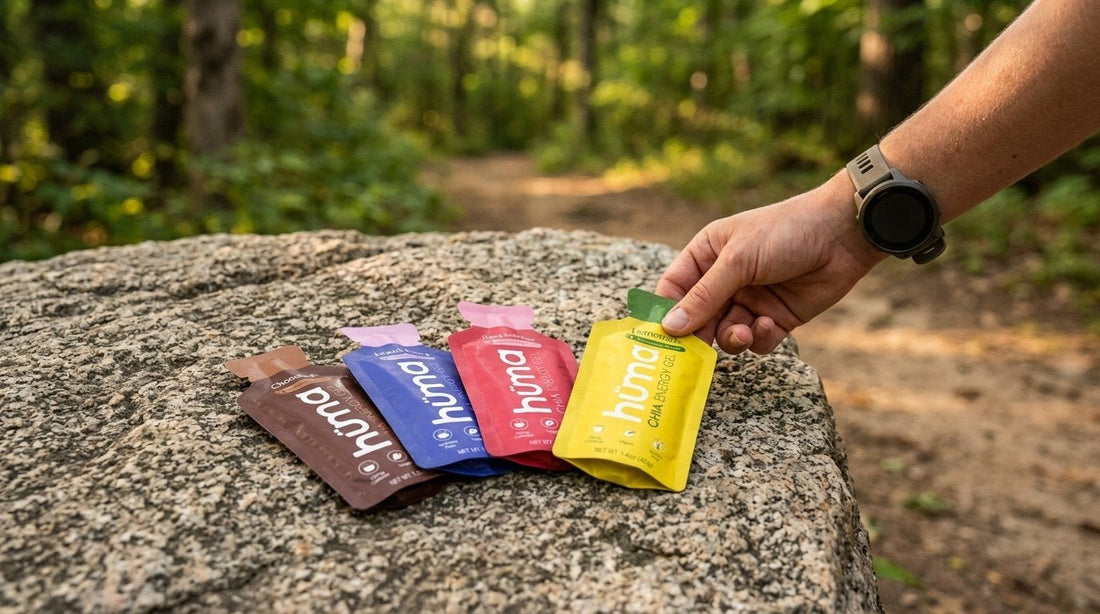 Runner choosing a Huma flavor from four gels spread on a trailside rock