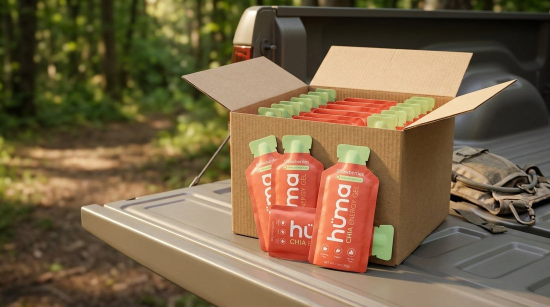 An open box of Huma Strawberries gels on a pickup tailgate at a trailhead